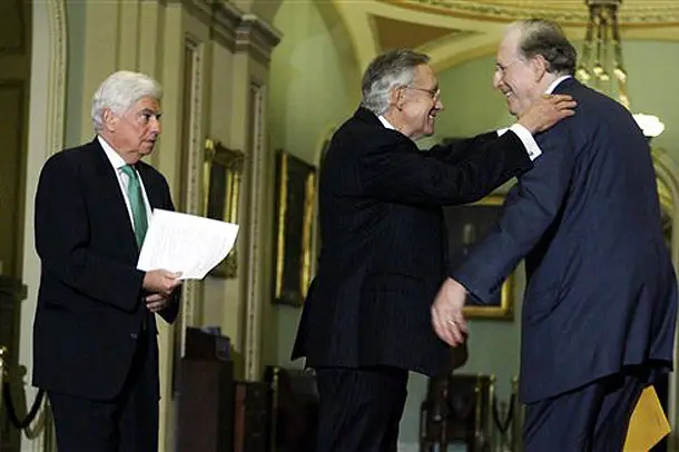 Photograph of Senate Majority Leader Harry Reid, D-Nev., center, embracing Sen. Jay Rockefeller, D-W.V., as Sen. Chris Dodd, D-Conn., left, looks on by Jose Luis Magana/